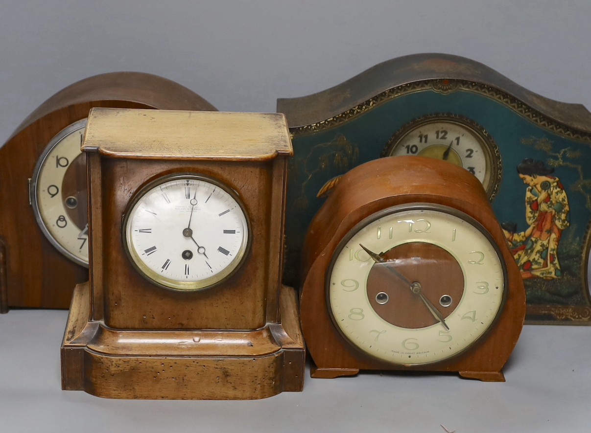 A tin mantel clock and 3 wooden clocks, 2 dog door stops and a blue and white plate.